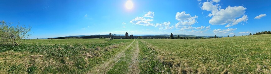 panorama of beautiful countryside of Rhoen, Hesse, Germany. sunny afternoon. wonderful springtime landscape in mountains. grassy field and rolling hills. rural scenery.