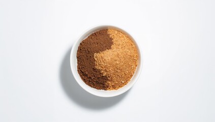 Various kinds of brown sugar in a bowl from above on a white background