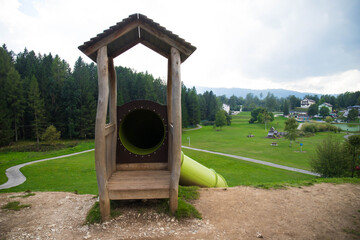 The entrance of the giant tunnel slide that descend from the hill at Pal&ugrave; Park, a huge playground located in Lavarone, Trentino, Italy. Background with copy space.