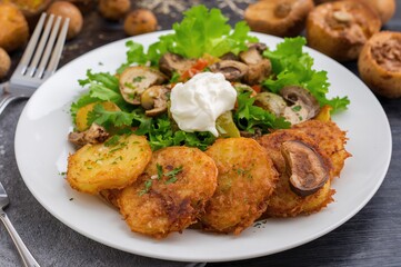 Fototapeta premium Crispy Potato Slices Served with Mushrooms and Fresh Vegetable Salad