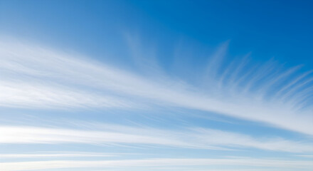 Wispy cirrus clouds streak across a vibrant blue sky, creating a delicate and airy natural landscape.