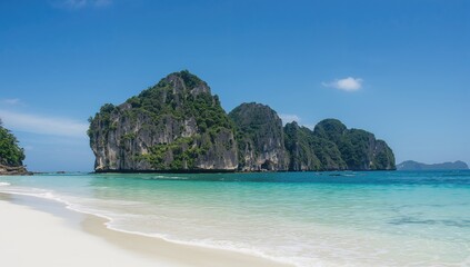 Fototapeta premium Crystal-clear turquoise waters and white sandy shores at a coastal spot in a tropical district.