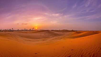 Panoramic view of a desert with golden sand dunes at sunset