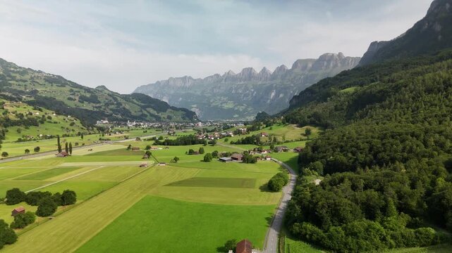 Scenic Aerial View of a Valley with Green Fields and Mountain Landscape in Switzerland near Flums, Berschis, and Walenstadt in the Canton of St. Gallen &ndash; Drone Footage