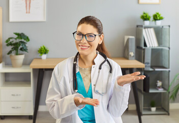 Portrait of a positive female doctor or nurse conducting online consultation via webcam and video call in hospital office, medical internet service, space of healthcare communication.