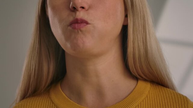 Close up of a woman preparing to eat a crispy rye cracker, with emphasis on facial features and texture. Slow motion.