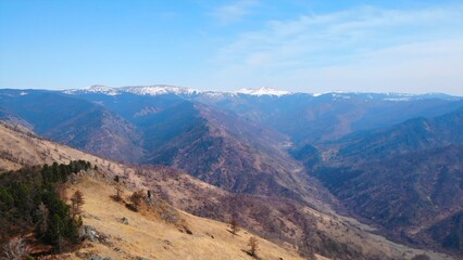 Fototapeta premium Majestic mountain range with snow capped peaks panning over valley. Media