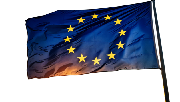 The flag of the european union, with its circle of stars, waving against a sunset white 