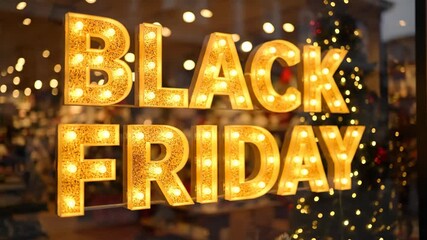 A bright and glowing Black Friday sign with vintage marquee light bulbs in a store window announces the start of the biggest holiday shopping sale and discount event. - Powered by Adobe