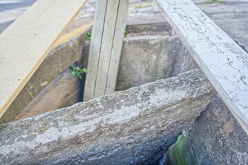 Broken and open manhole with a lot of dirt inside