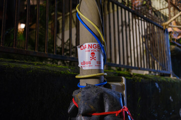 Electric pole with “Danger” warning sign and multiple electric wires in urban India, featuring...