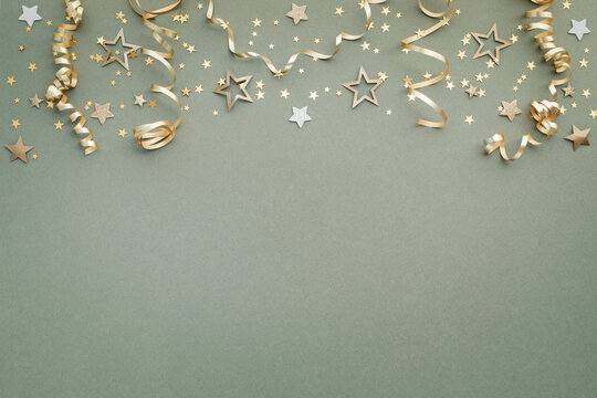 New Year, Christmas or birthday festive background top view. Celebration composition with golden confetti stars and serpentine party streamers.