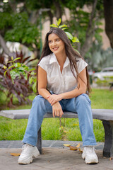 Obraz premium young woman sitting on bench in park