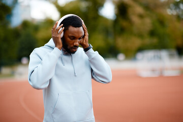 Athlete man putting on headphones for intense training