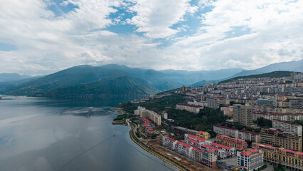 Aerial photography of a small town on the mountain by the riverbank