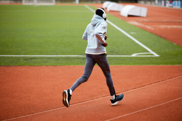 Obraz premium Person running on track wearing headphones