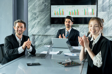 Caucasian man and multiracial colleagues clapping and smiling during business meeting, celebrating professional achievement inside office conference room, teamwork and cooperation visible in action