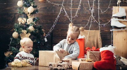 Happy children. Cheerful cute child opening a Christmas present. Happy child with a Christmas...