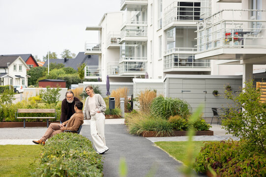 Family spending leisure time while talking with each other in garden near house