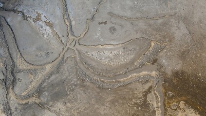 Overhead perspective of barren land featuring sandy cracks within an industrial construction area, showcasing a dry textured background.