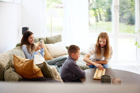 Smiling male and female siblings spending leisure time at home