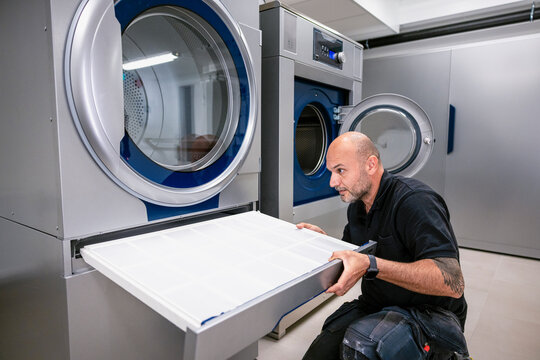 Engineer changing filter of washing machine