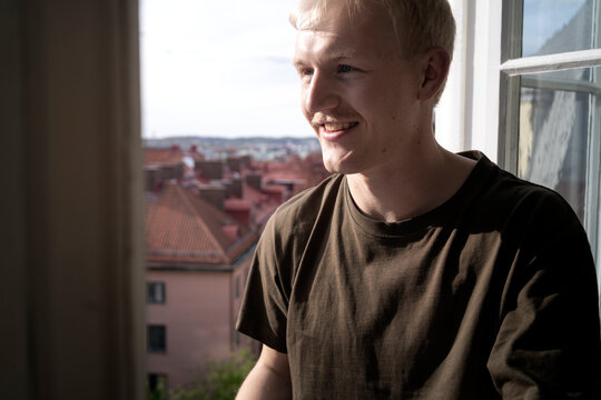 Smiling man with mustache at window