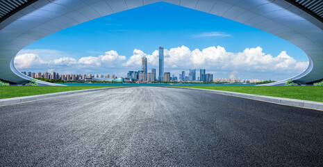 Empty asphalt road and bridge architecture with modern city skyline by the lake in Suzhou, China.