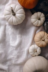 Elegant autumn flatlay featuring white and beige mini pumpkins placed on soft linen fabric with gentle natural light. Minimal warm fall decor concept, calm seasonal aesthetic.