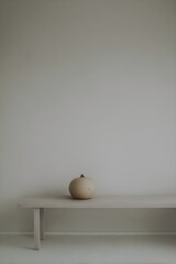 Minimal Cream Pumpkin on Wooden Bench with Soft Neutral Wall