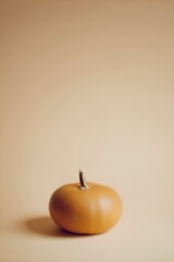 Bright Orange Pumpkin on Warm Beige Background
