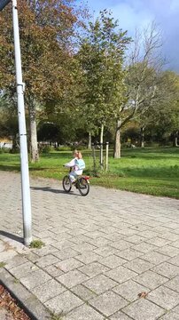 A child enjoys safe bicycle riding on pedestrian pathways after school hours, promoting healthy habits, environmental consciousness, and urban mobility from an early age.