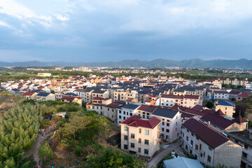 Obraz premium Aerial view of a town with colorful roofs, surrounded by nature and mountains
