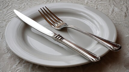 Elegant Silver Fork and Knife on White Plate Set in Soft Lighting for Dining and Food Presentation