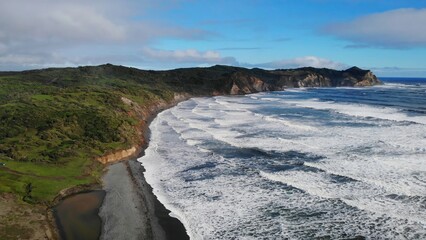 Ocean waves crashing on whatipu beach near auckland, new zealand