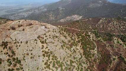 Aerial view flying over hilly landscape and mountains. Media