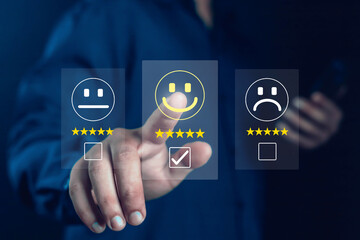 Customer satisfaction concept showing hand choosing happy smile face with five stars on virtual screen, representing positive feedback, online review, quality service, and user experience improvement.
