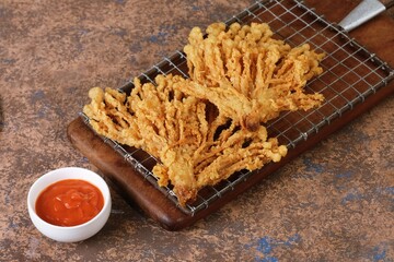 Golden brown crispy fried mushrooms on ceramic plate. Popular street food and appetizer, perfect for restaurant menus or snack ads.