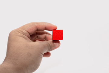 Hand Holding Red Wooden Block
