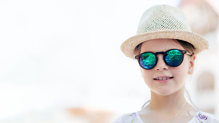Smiling girl in straw hat and sunglasses with copy space, stylish summer portrait outdoors, travel...