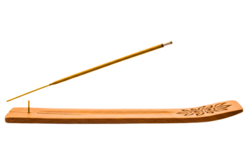 Wooden incense holder with decorative floral carving and incense stick on a transparent background