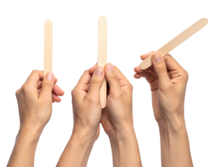 Three wooden medical tongue depressors are being held by hands against a transparent backdrop