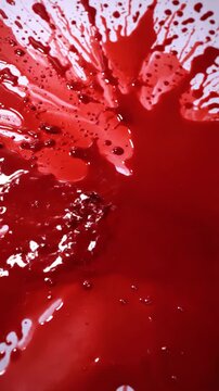 Abstract Red Blood Splatter - Close-up shot of a chaotic red splatter resembling blood, with both pooled and sprayed elements.