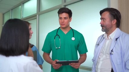 Multinational medical team discussing data on digital tablet in hospital. - Powered by Adobe