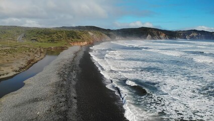 Breathtaking black sand beach meeting white ocean waves