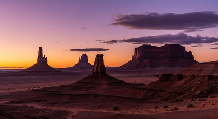 A Serene Purple Dawn Breaks Over Monument Valleys Iconic Silhouetted Buttes and Mesas.