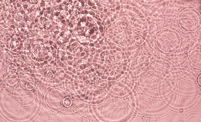 Pink water ripple texture background on the harsh light.