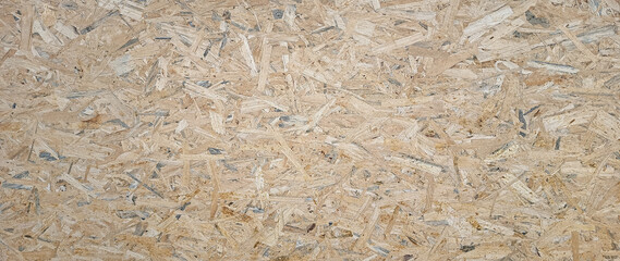 OSB boards made of brown wood chips sanded into wooden background. Wood plank texture background, surface texture of oriented board OSB, Wood board made from piece of wood