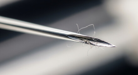 Close-up of a Needle Eye with Thread Ready for Sewing