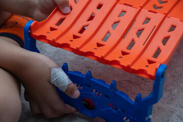 The child has a cut wound covered with a bandage